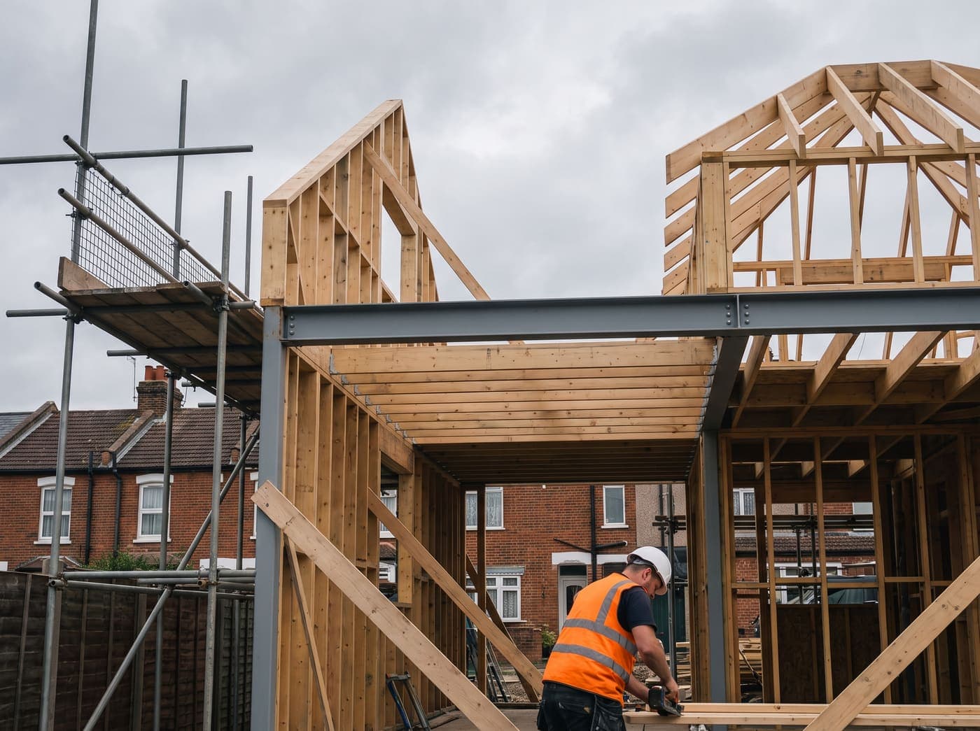 UK residential construction site mid-build, timber frame with scaffolding
